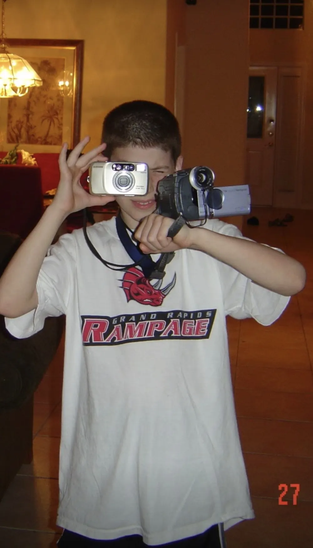 Gabriel as a kid, holding a photo camera and a video camera